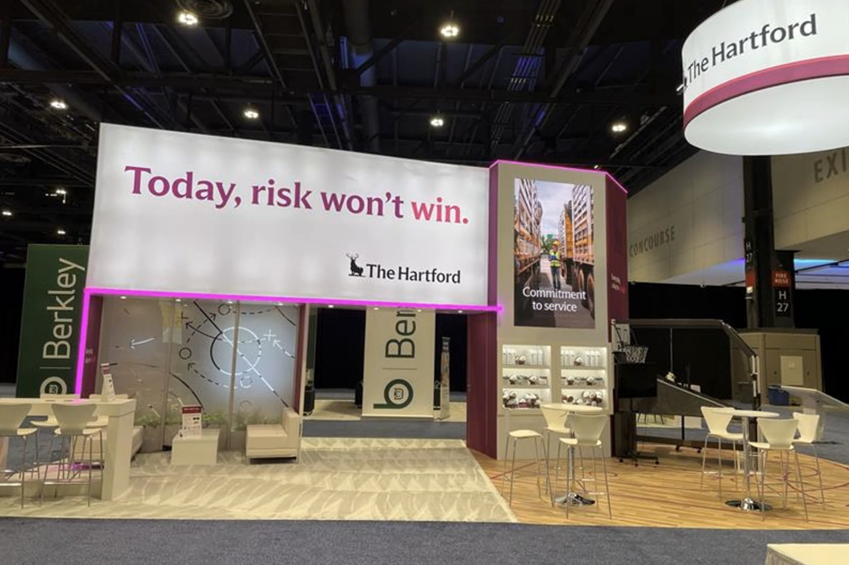 The Hartford RIMS 2025 booth in Chicago with a wide screen and tall vertical video display